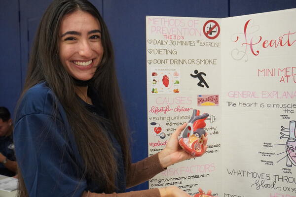 student showing heart model